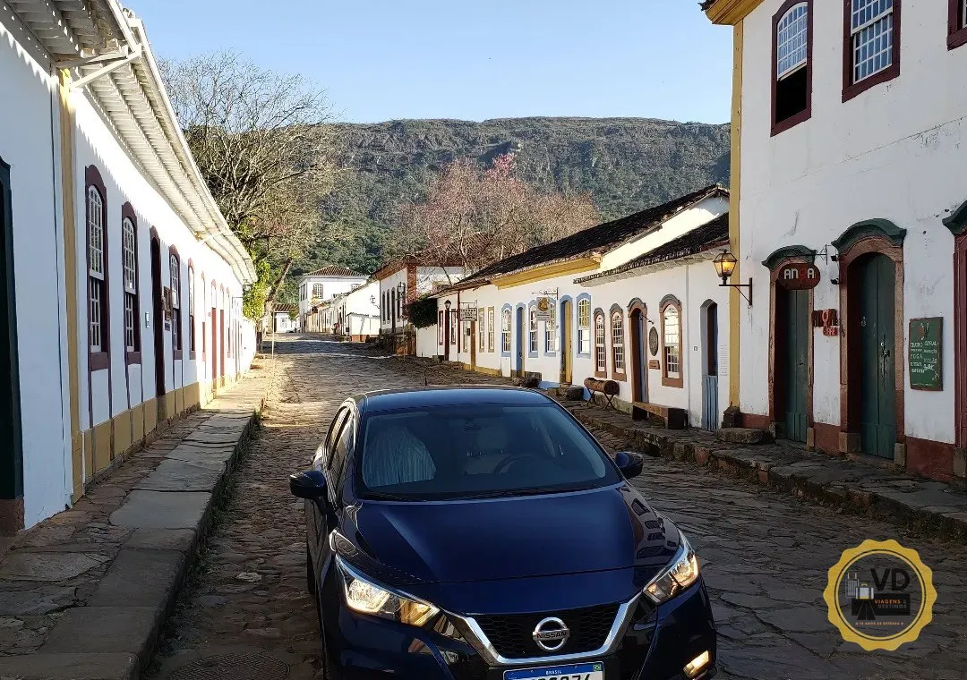Carro da VD Transportes na rua histórica de Tiradentes ao entardecer